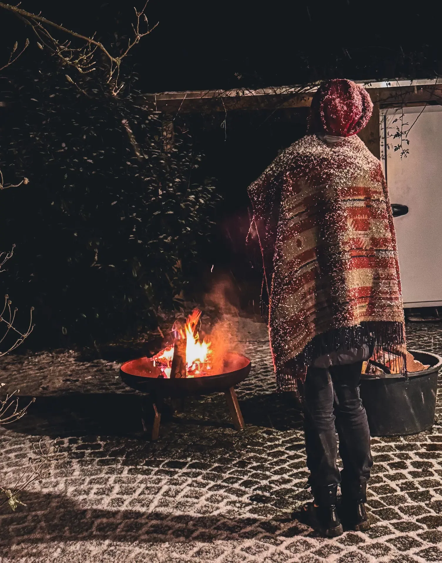 Eine Teilnehmerin steht nachts am Feuer