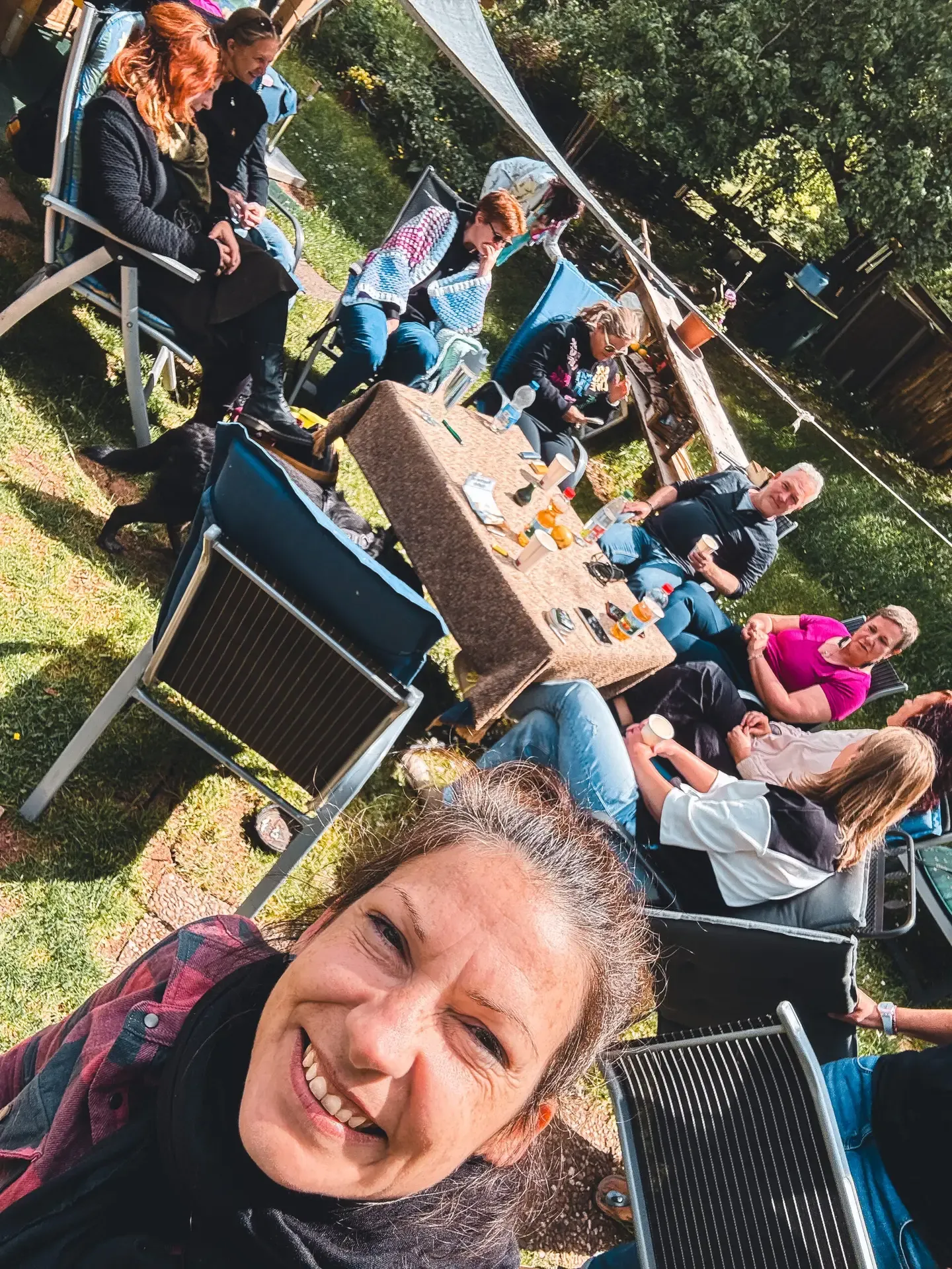 Die Gruppe sitzt in der Sonne im Garten